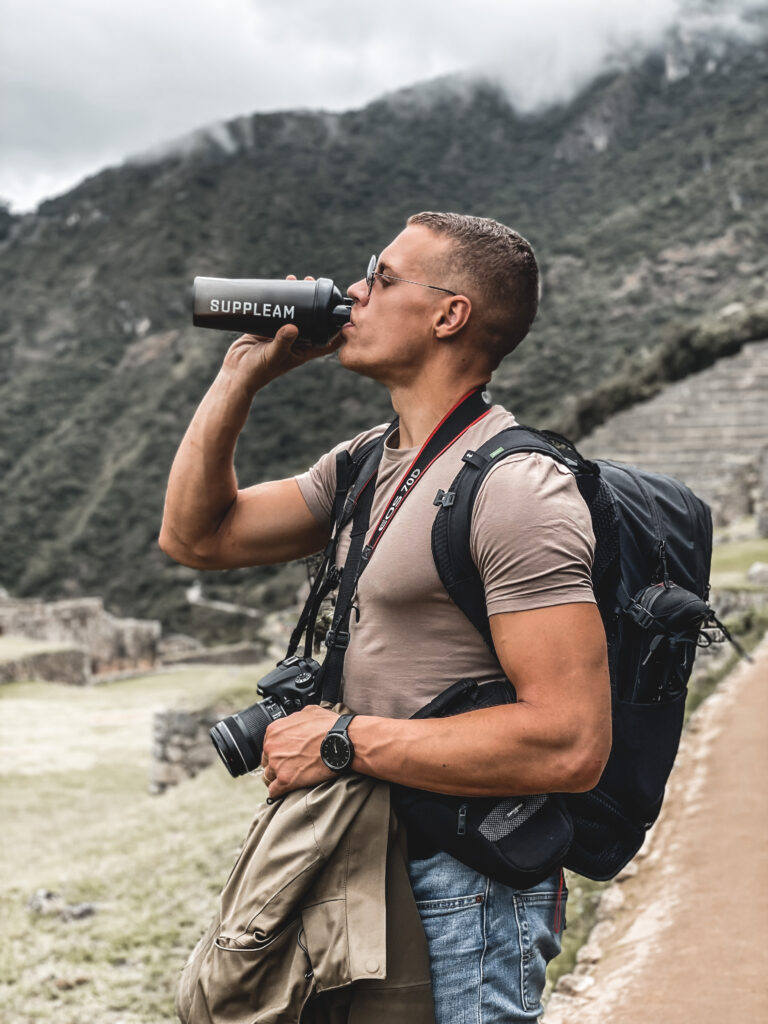 Reiziger in Machu Picchu Peru die een vegan proteïne shake drinkt